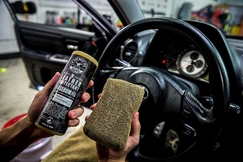A bottle of Chemical Guys Leather protectant and a sponge