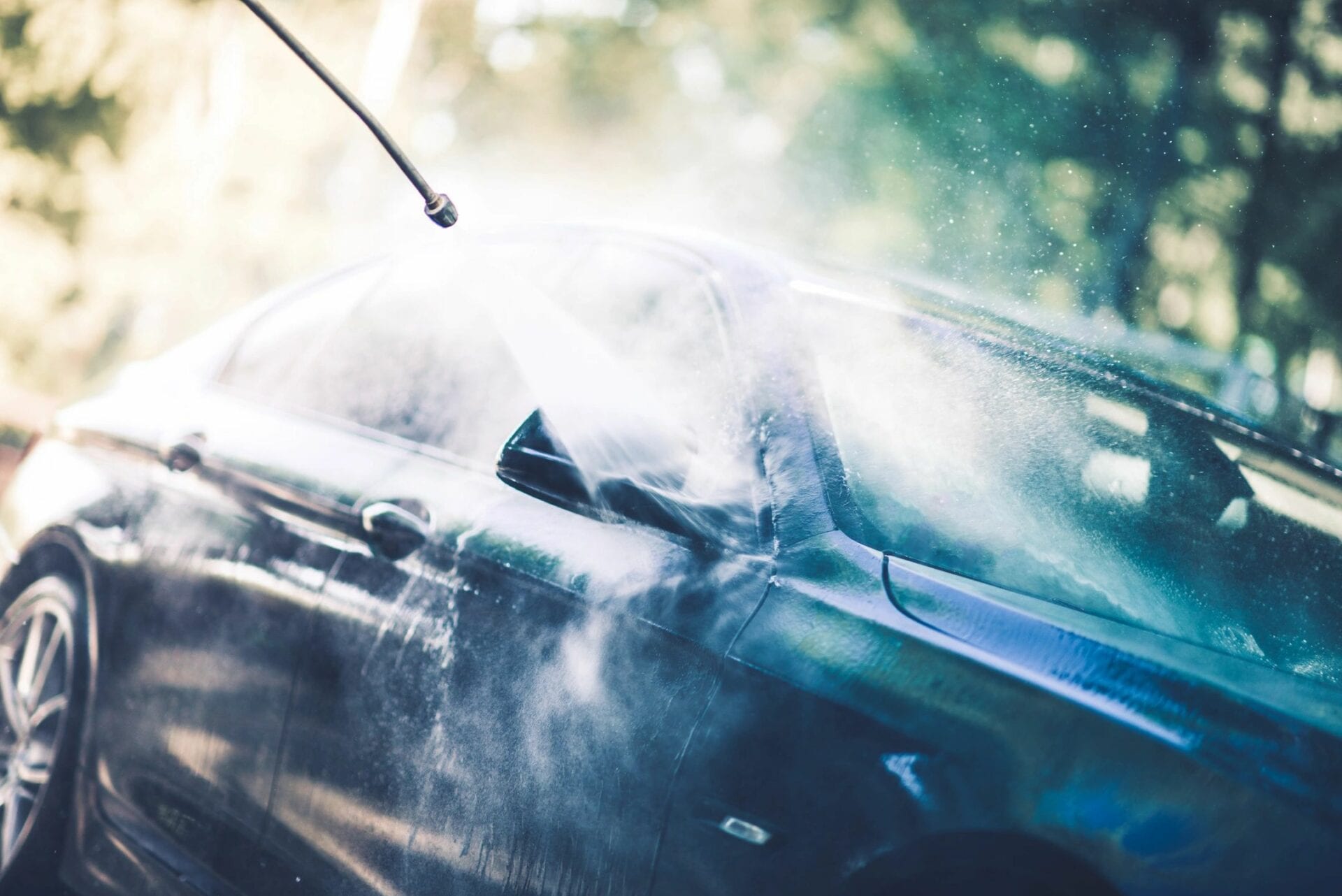 A car getting sprayed with water to clean it