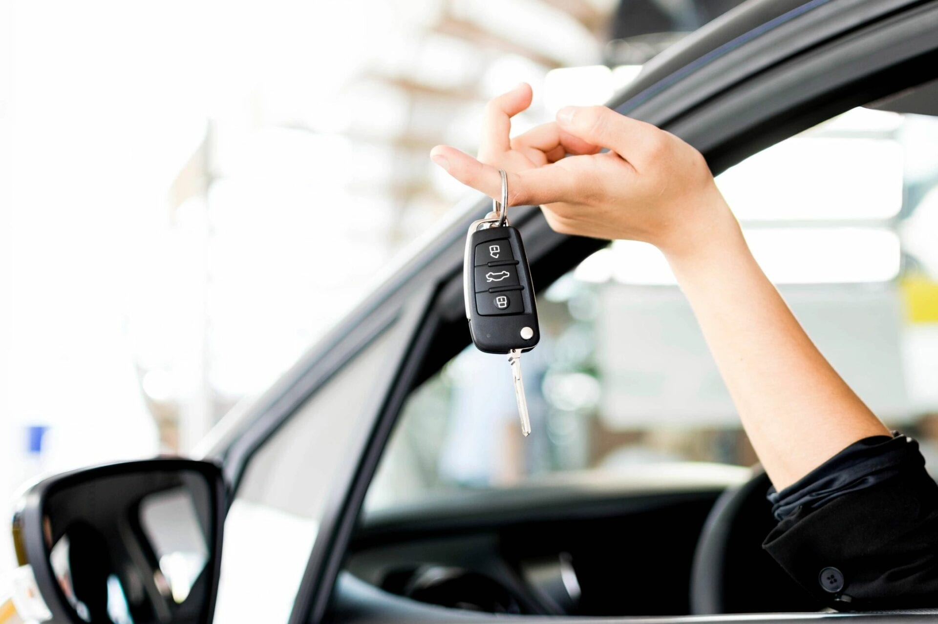 A person holding the keys to their newly-leased or rented car